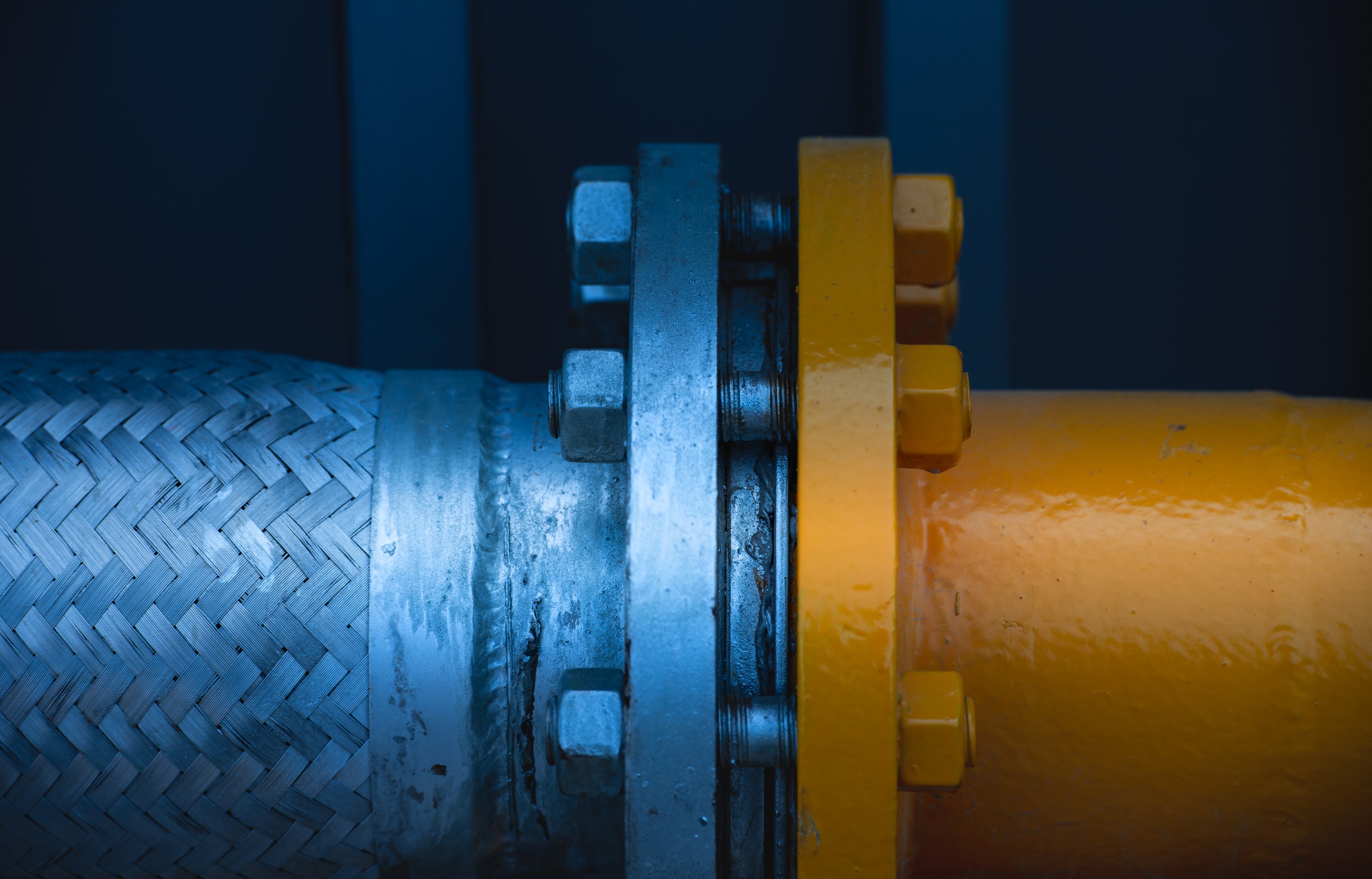 Blue and orange industrial components joined at a flange